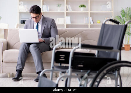 Dsabled Geschäftsmann auf Rollstuhl arbeiten Home Stockfoto