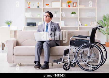 Dsabled Geschäftsmann auf Rollstuhl arbeiten Home Stockfoto