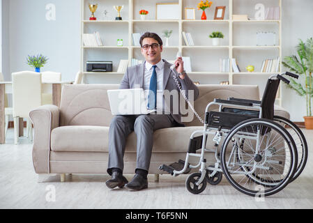 Dsabled Geschäftsmann auf Rollstuhl arbeiten Home Stockfoto