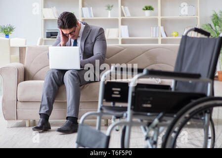 Dsabled Geschäftsmann auf Rollstuhl arbeiten Home Stockfoto