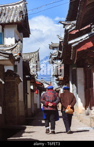 Lijiang, Yunnan, China: Zwei Frauen vorbei an traditionellen Naxi Architektur in der Altstadt von Lijiang, einem nationalen historischen und kulturellen Cit Stockfoto