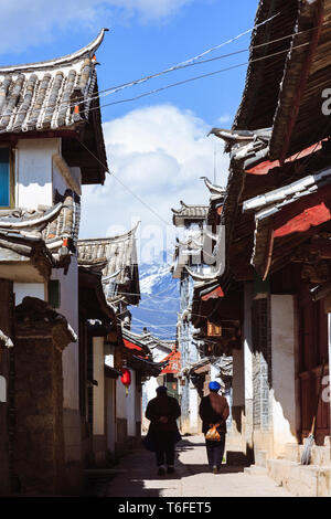 Lijiang, Yunnan, China: Zwei Frauen vorbei an traditionellen Naxi Architektur in der Altstadt von Lijiang, einem nationalen historischen und kulturellen Cit Stockfoto