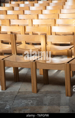 Einfache hölzerne Stühle in Reihen in der Kirche Stockfoto