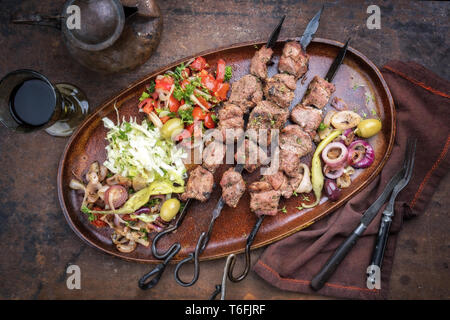 Traditionelle türkische Lamm Kebab Grill Spieß mit Kohl und Tomaten Zwiebel Salat als Draufsicht auf einer Platte Stockfoto