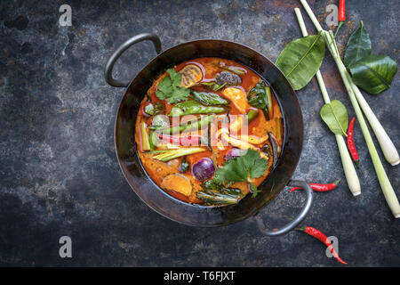 Traditionelle thailändische Kaeng phet Rotes Curry mit Gemüse als Draufsicht im Wok mit Kopie Raum links Stockfoto