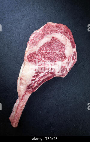 Raw trockenen Jahren wagyu Tomahawk steak als Close-up auf dem Schwarzen Brett Stockfoto