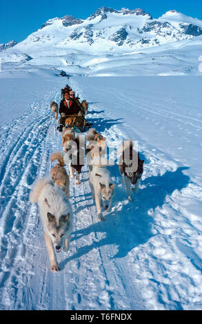 Inuits mit Hund sledgies Reisen bergauf, leichten, flexiblen Schlitten für Reisen in den Bergen eingesetzt, Ostgrönland, Grönland Stockfoto