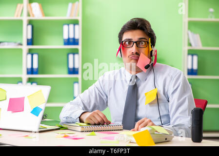 Junge help desk Operator arbeiten im Büro mit vielen gegensätzlichen Stockfoto