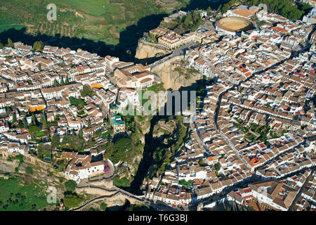 LUFTAUFNAHME. Historische, malerische Stadt, die durch einen tiefen Canyon halbiert wird. Ronda, Andalusien, Spanien. Stockfoto