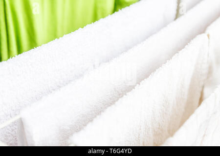 Weiße und farbige Bettwäsche und Handtücher auf der Wäscheleine getrocknet werden. Stockfoto