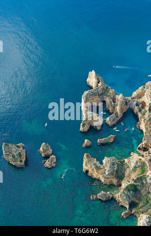 LUFTAUFNAHME. Tief erodierte Küstenlandschaft mit vielen Dolinen, Meereshöhlen und Buchten. Ponta da Piedade, Lagos, Algarve, Portugal. Stockfoto
