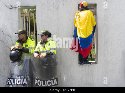 Bogota, Kolumbien. April 30, 2019 - eine Frau mit dem venezolanischen Flagge geht an den Bars der Venezolanischen Konsulat in Bogota und zwei Polizisten sind an ihrer Seite Credit: Daniel Garzon Herazo/ZUMA Draht/Alamy leben Nachrichten Stockfoto