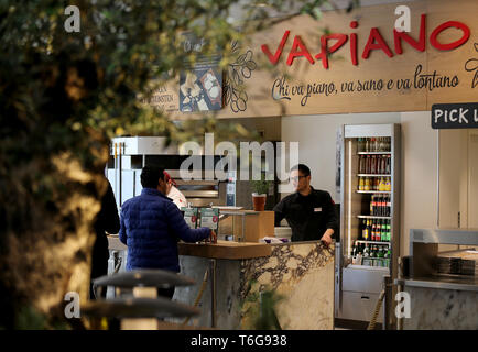 Köln, Deutschland. 30 Apr, 2019. Ein Mitarbeiter mit einem Kunden in einer Filiale der Restaurantkette Vapiano. Credit: Oliver Berg/dpa/Alamy leben Nachrichten Stockfoto