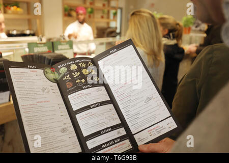 Köln, Deutschland. 30 Apr, 2019. Ein Mann hält ein Menü in seine Hand bei einer Filiale der Restaurantkette Vapiano. Credit: Oliver Berg/dpa/Alamy leben Nachrichten Stockfoto