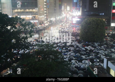 (190501) - TOKYO, Mai 1, 2019 (Xinhua) -- Menschen halten Regenschirme warten auf die bevorstehende Reiwa Ära im Shibuya Crossing in Tokio, Japan, 30. April 2019. Mit dem Ende der drei - Dekade lang Heisei Ära, Japan begann seine Neue Reiwa Ära am 1. Mai. Eine Anzahl von Einzelpersonen, Gemeinden, Städte und Landkreise in verschiedenen Arten in Japan in der neuen Reiwa Ära einläuten gefeiert. (Xinhua / Du Xiaoyi) Stockfoto