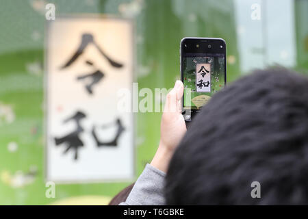 (190501) - TOKYO, Mai 1, 2019 (Xinhua) - ein Mann nimmt ein Foto der Kalligraphie "Reiwa" in Ginza in Tokio, Japan, Mai 1, 2019. Mit dem Ende der drei - Dekade lang Heisei Ära, Japan begann seine Neue Reiwa Ära am 1. Mai. Eine Anzahl von Einzelpersonen, Gemeinden, Städte und Landkreise in verschiedenen Arten in Japan in der neuen Reiwa Ära einläuten gefeiert. (Xinhua / Du Xiaoyi) Stockfoto