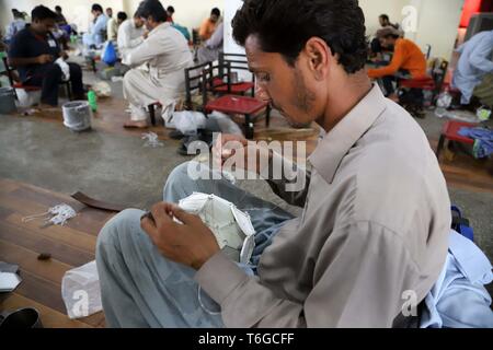 Sialkot. 12 Apr, 2019. Foto aufgenommen am 12 April, 2019 zeigt ein Arbeiter nähen ein Fußball bei einem Fußball-Fabrik im östlichen Pakistan Sialkot. Sialkot, eine Stadt in der pakistanischen Provinz Punjab, ist ein Zentrum der Handgenähter Fußball in der Welt und in seiner Zeit der Herrlichkeit, die Stadt einmal war, um mehr als 75 Prozent der weltweiten Nachfrage nach Fußball. Credit: Ahmad Kamal/Xinhua/Alamy leben Nachrichten Stockfoto