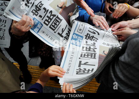 Die Leute versuchen eine Kopie von extra Ausgabe einer Zeitung, die über neue Kaiser Naruhito die Himmelfahrt auf der Vorderseite in Tokios Einkaufsviertel Ginza, Japan am 1. Mai 2019, dem ersten Tag der Reiwa Ära. Credit: Naoki Nishimura/LBA/Alamy leben Nachrichten Stockfoto