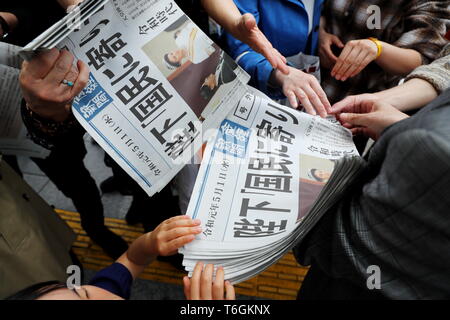 Die Leute versuchen eine Kopie von extra Ausgabe einer Zeitung, die über neue Kaiser Naruhito die Himmelfahrt auf der Vorderseite in Tokios Einkaufsviertel Ginza, Japan am 1. Mai 2019, dem ersten Tag der Reiwa Ära. Credit: Naoki Nishimura/LBA/Alamy leben Nachrichten Stockfoto