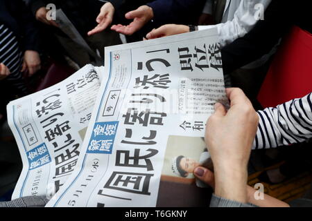 Die Leute versuchen eine Kopie von extra Ausgabe einer Zeitung, die über neue Kaiser Naruhito die Himmelfahrt auf der Vorderseite in Tokios Einkaufsviertel Ginza, Japan am 1. Mai 2019, dem ersten Tag der Reiwa Ära. Credit: Naoki Nishimura/LBA/Alamy leben Nachrichten Stockfoto