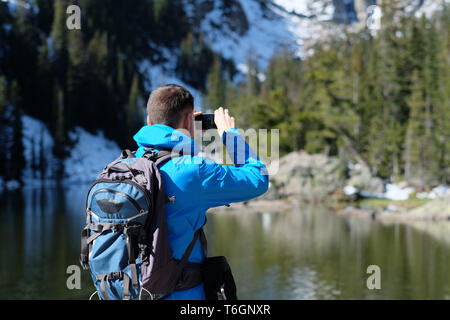 Backpacker unter Foto mit Smartphone Stockfoto