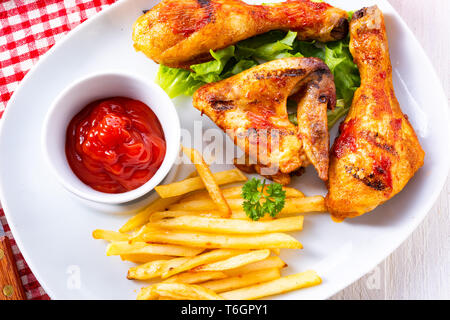 Gegrillte Chicken Wings, Beine, Pommes und Gemüse Stockfoto