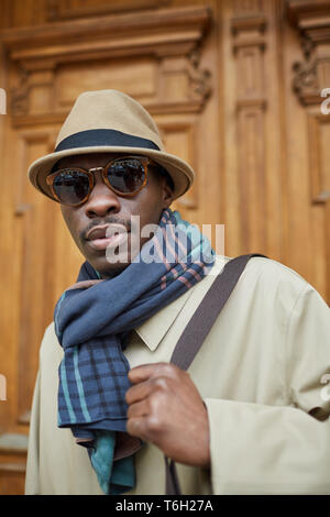 Portrait des modernen afrikanischen Mann mit Trenchcoat posiert im Freien in der Stadt Stockfoto