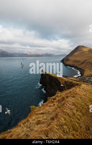 Das kleine Dorf Gjógv und die umliegenden Berge und das Meer, wie man es von einem steilen Felsen gesehen mit einem malerischen Wanderweg (Färöer, Dänemark, Europa) Stockfoto