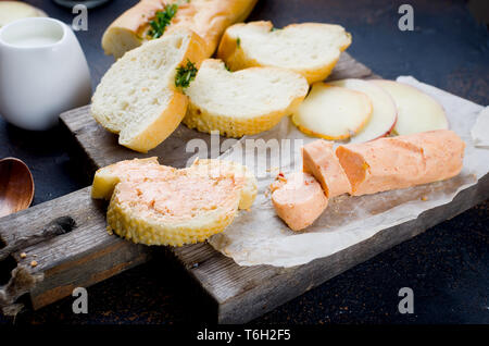 Verschiedene hausgemachte cheesy Pasta filata, Provolone in verschiedenen Formen und Größen auf dem hölzernen Hintergrund, suluguni, Zopf, Caciocavallo mit Tomaten eine Stockfoto