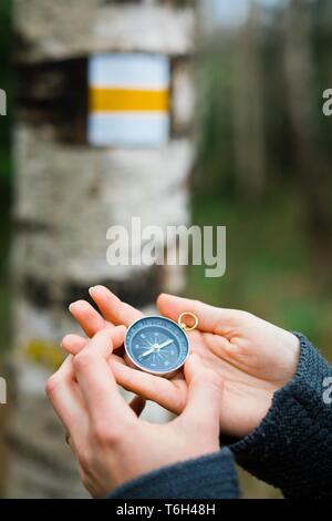 Die Frau Hände mit Kompass von Touristen Zeichen - auf der Suche nach der richtigen Richtung Stockfoto
