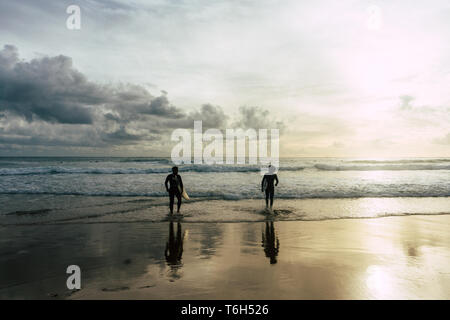 Dramatische Foto von zwei Surfer in den Ozean mit ihren Surfboards Stockfoto