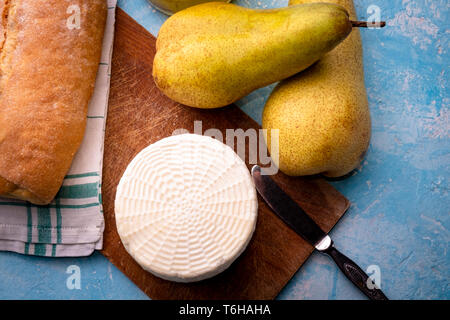Birnen und Käse auf dem Tisch mit Öl und Brot Stockfoto