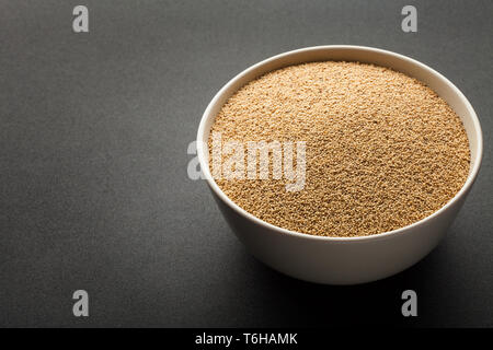 Amaranth Samen in Keramik Schüssel auf dunklem Hintergrund isoliert Stockfoto