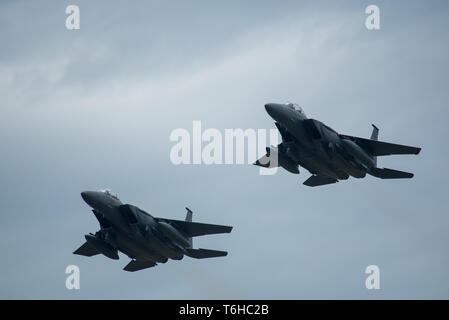 Zwei F-15E Strike Eagles, auf den 4. Fighter Wing zugeordnet sind, führen Sie eine Überführung während der Nationalhymne an den Flügeln über Wayne Air Show, 28. April 2019, bei Seymour Johnson Air Force Base, North Carolina. Während der Eröffnungsfeier der Schwarze Dolch, der offiziellen U.S. Army Special Operations Command Parachute Demonstration Team, durchgeführt werden, da die F-15E Strike Eagles eine Überführung durchgeführt. (U.S. Air Force Foto von älteren Flieger Shawna L. Keyes) Stockfoto