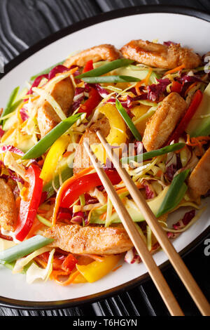 Asiatische Kohl Salat mit Hühnchen und Gemüse close-up auf einem Teller auf den Tisch. Vertikale Stockfoto