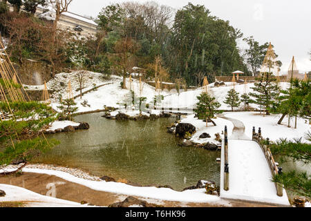 Gyokusen inmaru Japanischen Garten, die ursprünglich im Jahre 1634 erbaut. Garten, Teich, die Brücke und die erste Insel bei Schneefall. Burg Kanazawa, Japan. Stockfoto