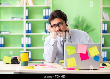 Junge help desk Operator arbeiten im Büro mit vielen gegensätzlichen Stockfoto