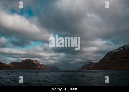 Blick auf Kalsoy Insel und Kunoy Insel als von einer Fähre zur Insel Kalsoy mit dramatischen bewölkter Himmel gesehen (Färöer, Dänemark, Europa) Stockfoto