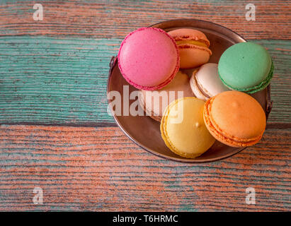 Metallplatte mit Französische macarons auf einem Holztisch Stockfoto