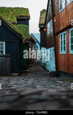 Kleine Gasse im Zentrum von Tórshavn (Färöer) mit typischen schwarzen und roten Holzhäuser mit Moos bedeckten Dächer (Färöer Inseln) Stockfoto