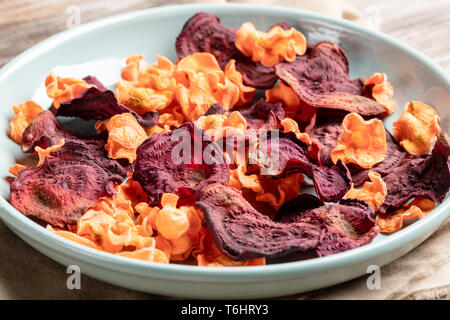 Close-up türkis Platte mit Chips von Karotten und rote Beete. Stockfoto