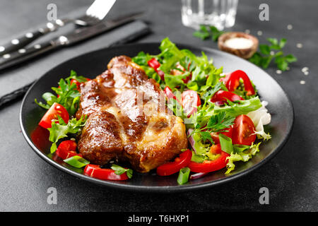 Gebackene Schweinesteak mit frischen Salat auf einen Teller Stockfoto