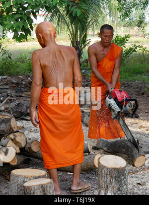 Ein buddhistischer Mönch tragen Safranroben Brennholz mit einer Kettensäge. Kampong Thom, Kambodscha, 20-12-2018 Stockfoto