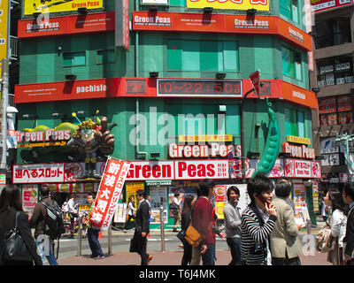 Grüne Erbsen Pachislo Pachinko und Menschen auf einem Platz am Shinjuku JR Bahnhof Süd Ausfahrt, Tokio, Honshū, Japan Stockfoto