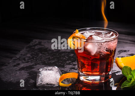 Mezcal Negroni Cocktail. Smoky italienischen Aperitivo. Geflammt Orange Peel. Stockfoto