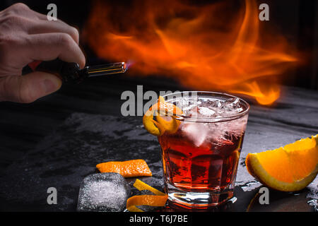 Mezcal Negroni Cocktail. Smoky italienischen Aperitivo. Geflammt Orange Peel. Stockfoto