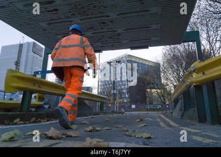 Ein Bauarbeiter Spaziergänge durch den alten Eingang zum Covent Garden Flower Market und der neuen US-Botschaft in London. 22/11/2017 Stockfoto