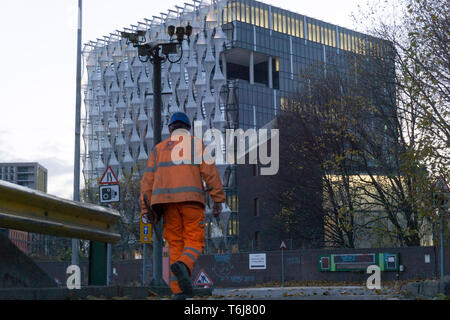 Ein Bauarbeiter Spaziergänge durch den alten Eingang zum Covent Garden Flower Market und der neuen US-Botschaft in London. 22/11/2017 Stockfoto