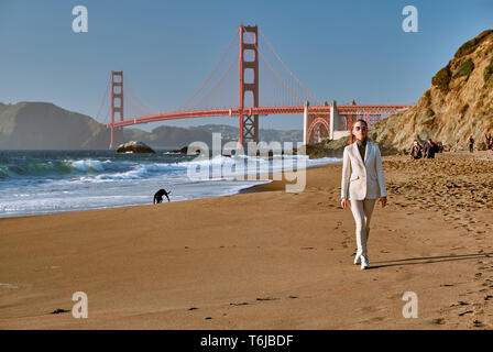 Frau zu Fuß am Strand und in der Nähe von Golden Gate Bridge Stockfoto