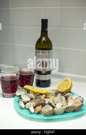 Lecker clam Spisula-muschel-auf Folie Kochen im Ofen gegrillte Neben Gläsern und einer Flasche roten Granatapfel Wein Stockfoto